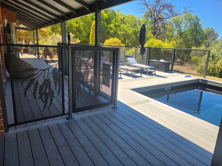 The pool is set into a raised deck. The balustrade and the gate are the pool fence.