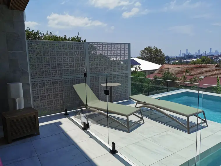 A Nahosh screen beside a pool, with the city skyline in the distance.