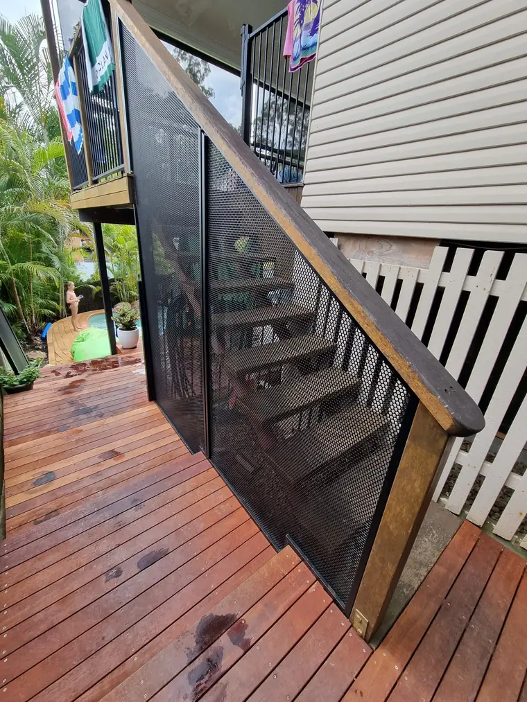 Panels cut on an angle down a timber stair beside the house.