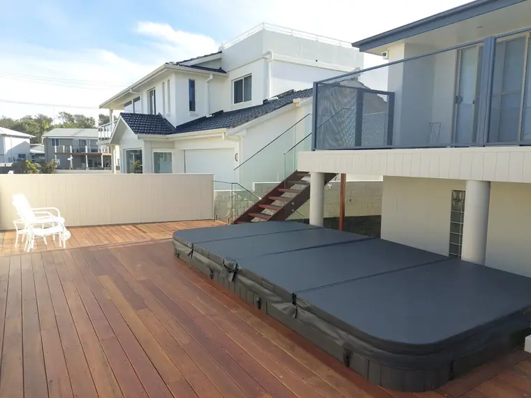 A spa on a new deck, with the balcony above.