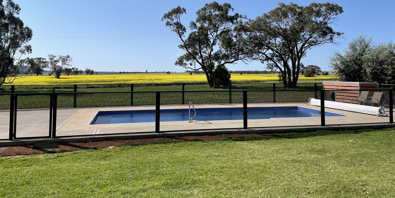 Pure Perf perforated pool fencing in Textured Black - the fence all but disappears into the view beyond